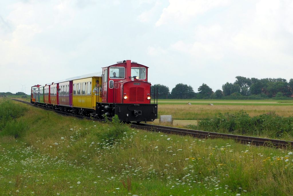 Weite Insellandschaft umgibt die Langeooger Inselbahn - hier kurz nach Verlassen des Hafenbahnhofs am 25.07.2015.