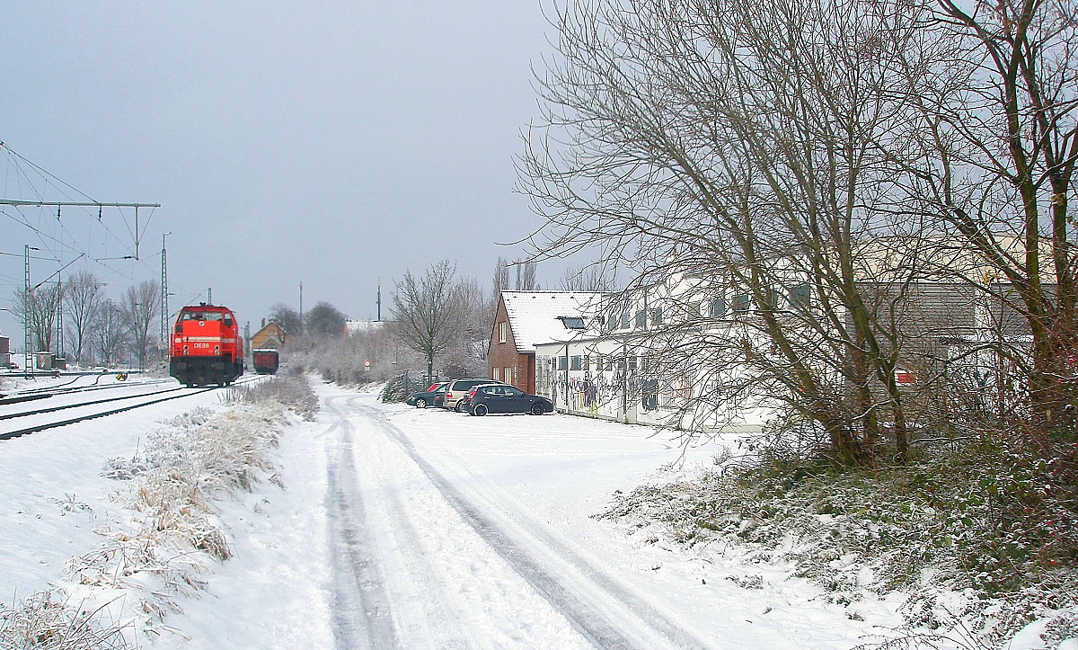 Weitgehend schneeweiss präsentierte sich der Bahnhof Nievenheim an der Bahnstrecke Köln-Neuss am 17.12.2010. Hier beginnt die Industriebahn zum Rheinhafen Stürzelberg und zur Aluminiumhütte Neuss-Norf. Auf dem Anschlussgleis steht DE 86 der HGK Köln, rechts der Lokschuppen der Industriebahn.
