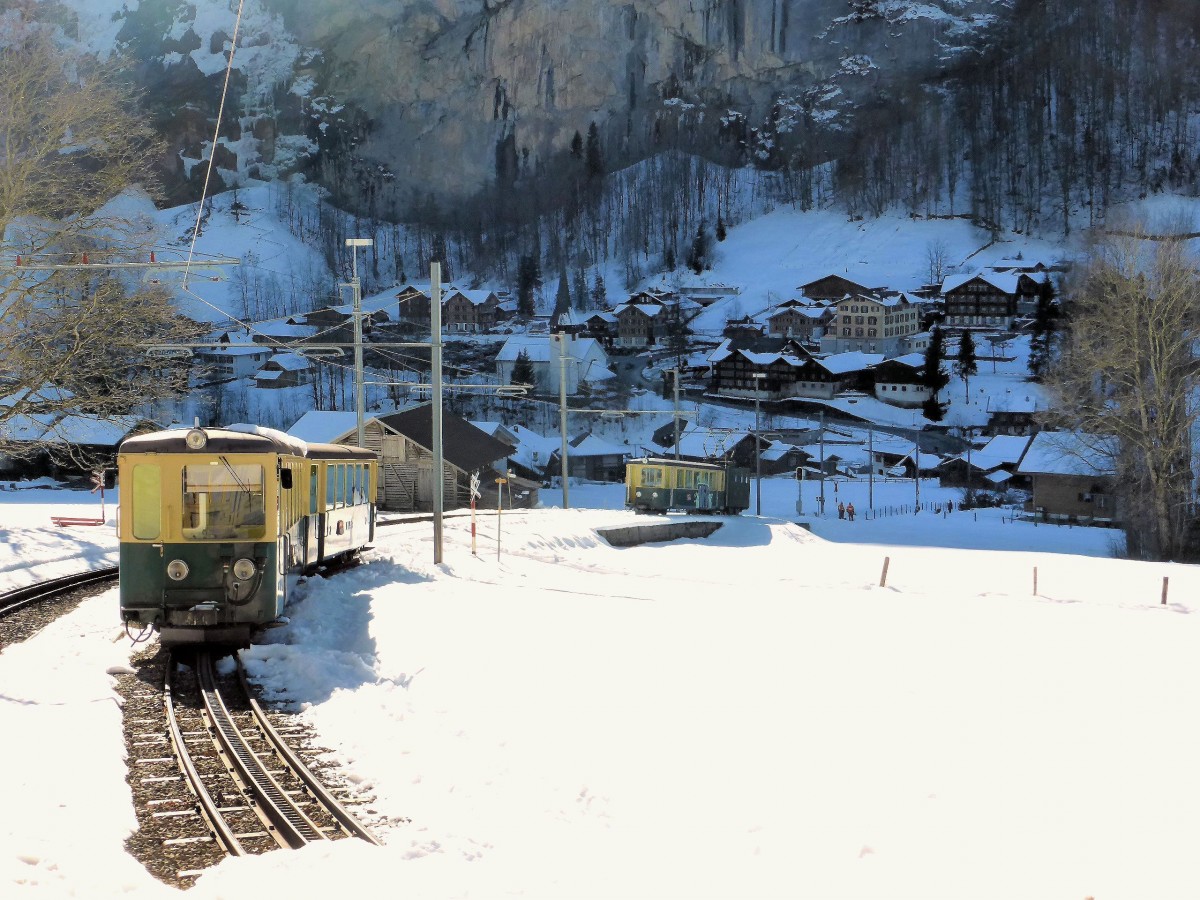Wengernalpbahn - Sonne und Schatten: In der warmen Sonne stehen der Steuerwagen 265 und der Personenwagen 223, während Lok 64 mit Wagen 221 bereits der eisigen Welt des Talgrunds von Lauterbrunnen zustreben. 20.Februar 2015.  