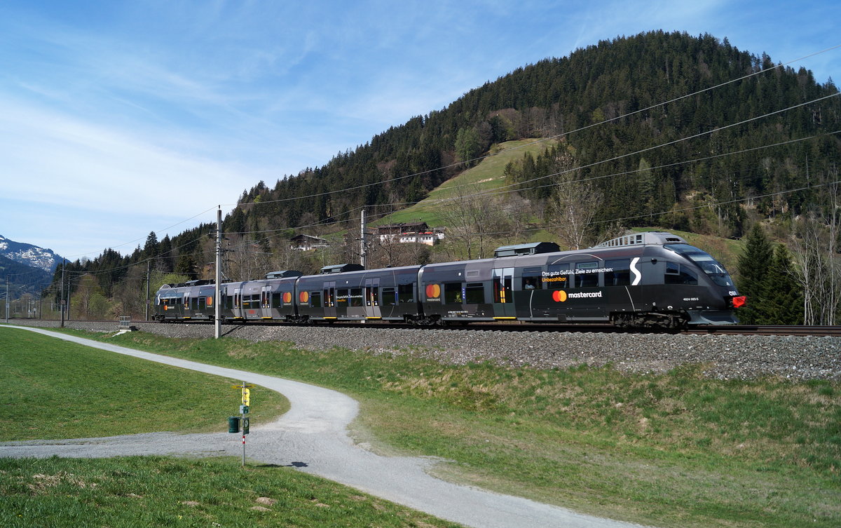 Wenig Nahverkehr herrscht an Feiertagen auf der Salzburg-Tiroler-Bahn rund um Kitzbühel. Umso erfreulicher war es, dass für den S-Bahn-Takt Wörgl - Hochfilzen am Ostermontag dieses Jahres der 4024 085-5  Mastercard  eingeteilt war. Kurz vor Kitzbühel Schwarzsee ist die Garnitur hier als Zug 5019 auf dem Weg Richtung Hochfilzen und konnte im Ortsteil Gundhabing bildlich festgehalten werden. 22.04.2019.