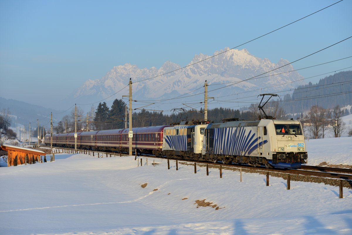 Wenige Minuten später kam D 13187 von Hamburg HBF nach Schwarzach St. Veit durch Fieberbrunn gefahren. Geführt wurde dieser Turnuszug von 185 662 und 139 133, zur Enttäuschung der anwesenden Eisenbahnfreunde war die Drehstromlok führend. Im Hintergrund das Bergmassiv des Wilden Kaisers.