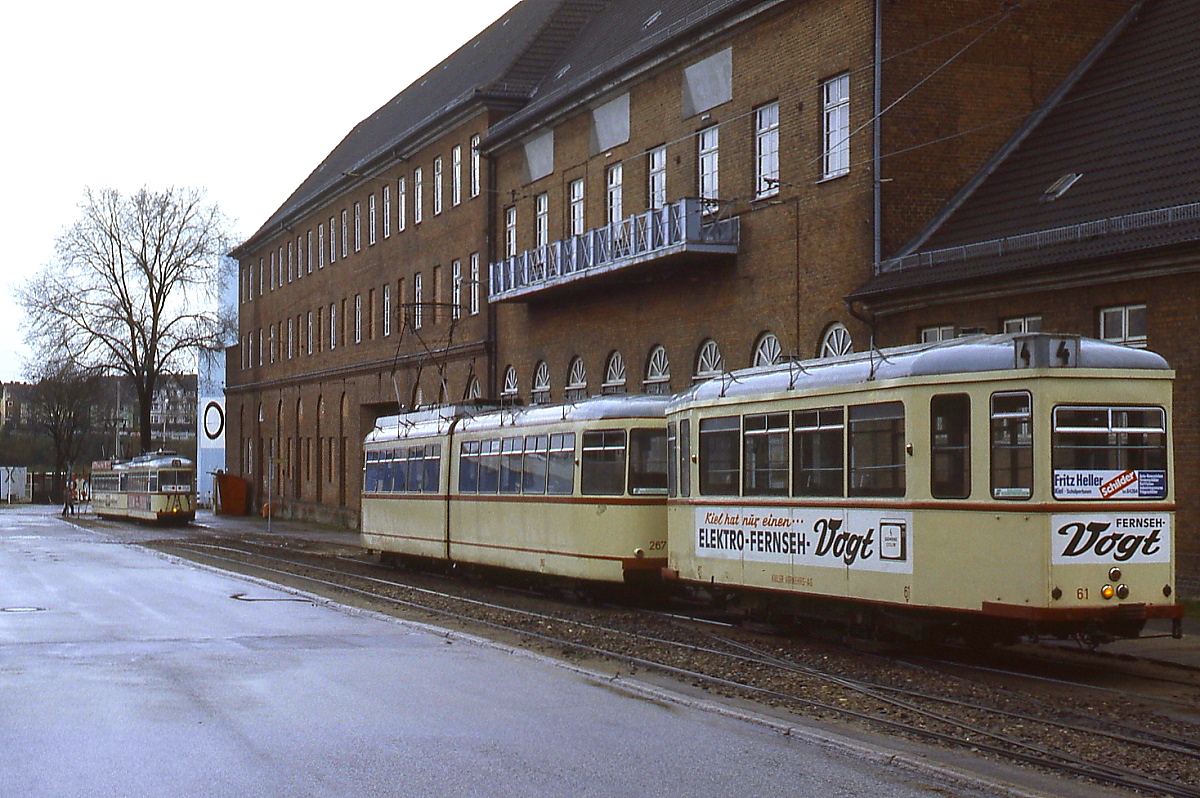 Wenige Wochen vor der Stilllegung der Kieler Straßenbahn stehen Tw 267 und Bw 61 am 27.04.1985 in der Endhaltestelle Schleuse Holtenau, vorn beginnt gerade ein Großraumwagenzug seine Fahrt in Richtung Wellingdorf
