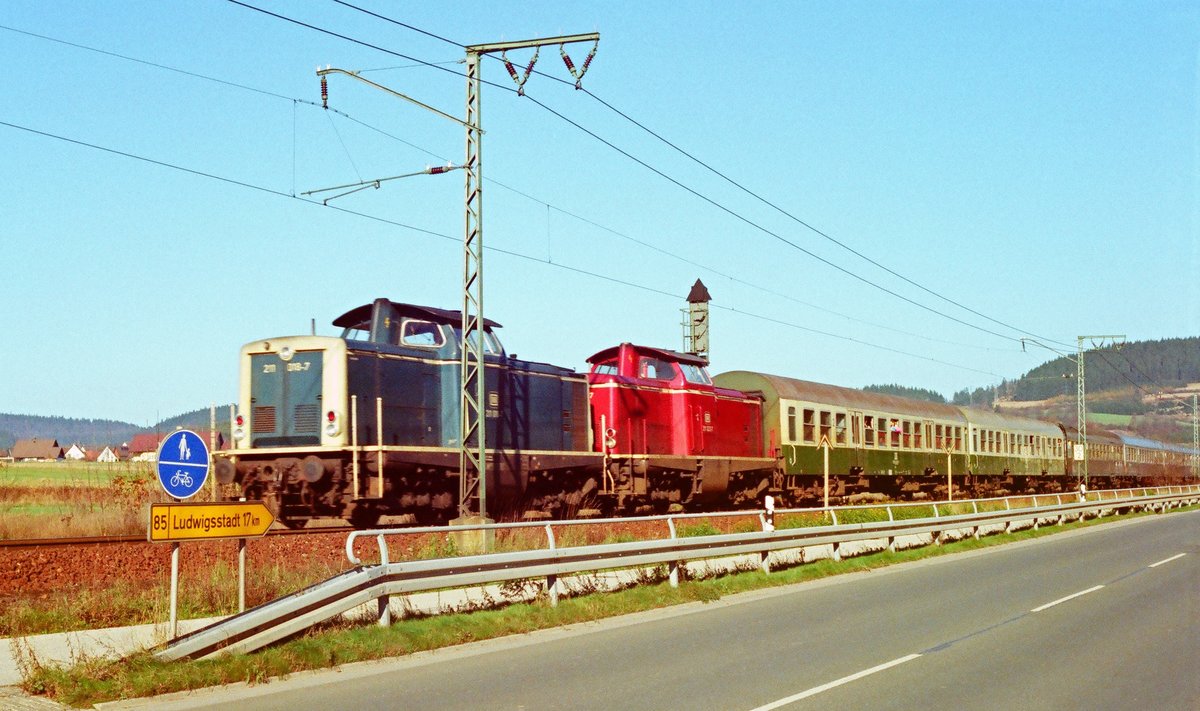 Wenn in diesen Tagen alle Medien voller Beiträge zur Grenzöffnung vor 30 Jahren sind, darf  bahnbilder  auch einen Beitrag liefern. Am 12. November 1989 fährt auf der noch eingleisigen Strecke ein mit erwartungsvollen Reisenden gut besetzter, in Eile zusammengestellter Zug durch Rothenkirchen. Der Wegweiser im Vordergrund wird in wenigen Tagen schon nach Saalfeld weisen.