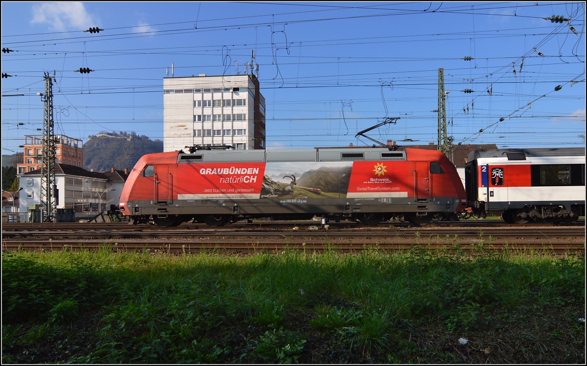 Wenn jemand sagt, es gäbe keine Steinböcke am Hohentwiel, hier ist der Gegenbeweis. 101 017-2 mit Graubündenwerbung erscheint ein wenig grau in der Industriestadt. Nebst meiner unsinnigen Iso-Einstellung hat die DB auch ihr Scherflein zum grauen Erscheinungsbild von Graubünden beigetragen. Singen, Oktober 2014.