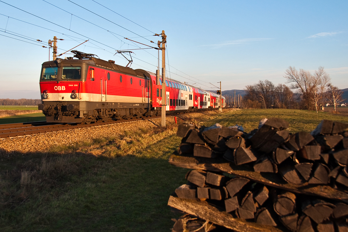 Wenn der Winter kalt werden sollte, die Holzscheite liegen schon bereit: 1144 258, unterwegs mit REX 7120 nach Krems/Donau, kurz vor Muckendorf-Wipfing, am 30.11.2013.