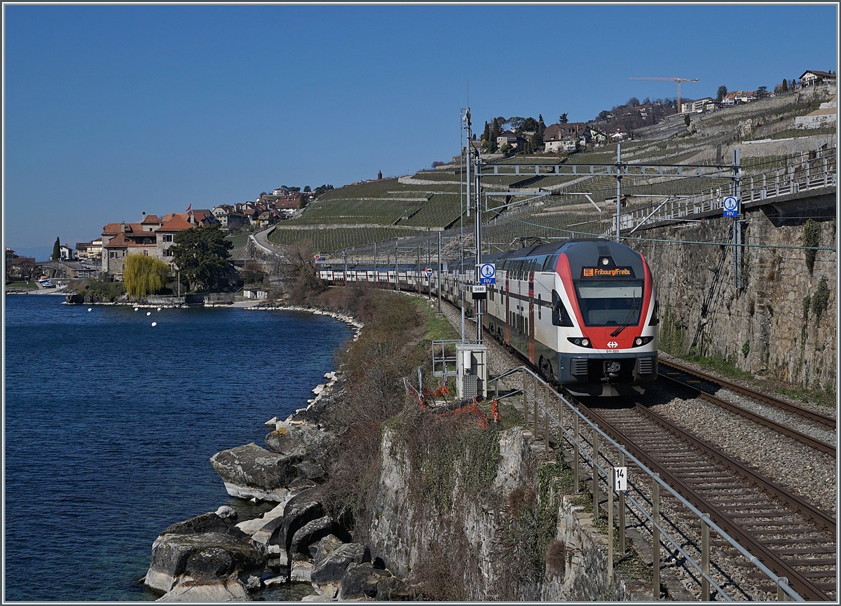 Wer auch nur eine geringe Ahnung von Bahngeografie hat, schaut bei diesem Bild zweimal hin: Ein RE nach Fribourg / Freiburg am Genfersee? 
Grund dafür sind Stellwerks Arbeiten in Lausanne welche es nötig machten, den Zugverkehr stillzulegen, wobei auch hier: Keine Regel ohne Ausnahme: das Gleis 8 in Lausanne bleibt während der Umbauphase grösstenteils befahrbar. Folglich können zwei Zugspaare pro Stunde den Bahnknoten befahren. Dazu gehörten ein IR 90 von Genève nach Brig und ein aus dem Sommerfahrplan 2018 bestens bekannter RE von Genève Fribourg via Vevey. Und ein solcher ist hier zu sehen. Die beiden SBB RABe 511 020 und 019 sind als RE 30011 zwischen Rivaz und St Saphorin auf dem in Fahrtrichtung rechten Gleis unterwegs. 

20. März 2021