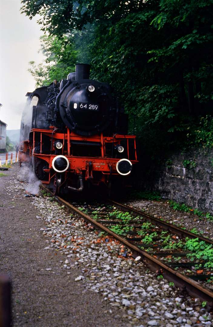 Wer nach Eyach fährt, entdeckt dort gleich zwei Bahnhöfe in unmittelbarer Nähe: den DB-Bahnhof und den Bahnhof Eyach Landesbahn der HZL. Dampflok 64 289 (EFZ) lässt den Landesbahnhof am 22.07.1987 lebendig werden.