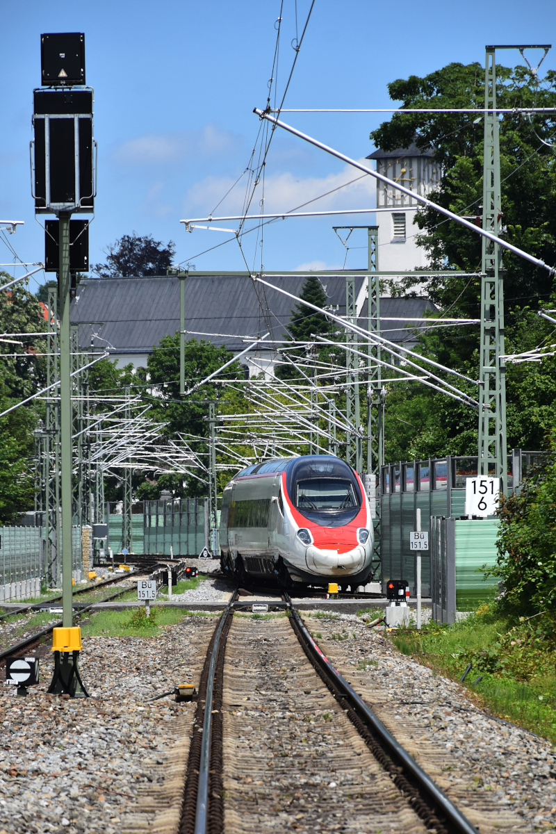 Wer schleicht da um die Kurve? Ein (naturgemäß unbekannt gebliebener - oder kennt jemand die asymmetrische Nase?) ETR 610 hat am 03.07.2021 von Lindau Reutin kommend die Aeschacher Kurve im Schneckentempo verlassen, um nun auf seiner Fahrt nach München wieder Geschwindigkeit aufzunehmen.
Mein Standort: Am (natürlich geöffneten!) Bahnübergang Hasenweidweg.