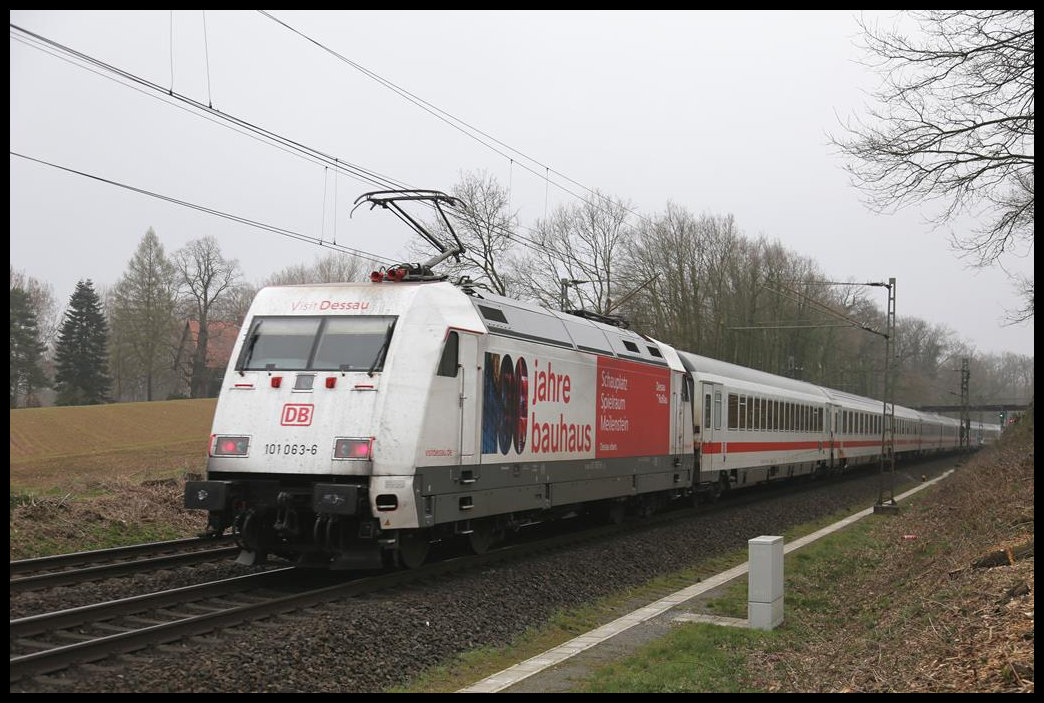 Werbelok  Bauhaus  101063-0 schiebt hier am Ortsrand von Hasbergen den IC 2212 nach Binz am 23.3.2019 um 9.20 Uhr über die Rollbahn nach Norden.