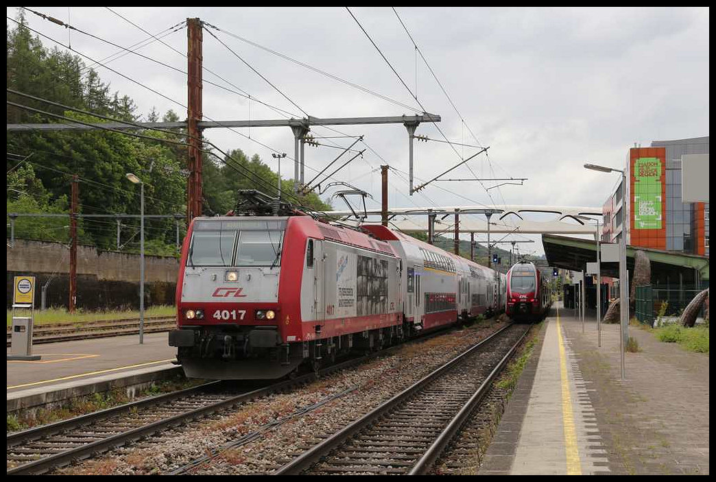Werbelok CFL 4017 fährt hier am 23.05.2023 um 13.20 Uhr mit einem Dosto aus dem Bahnhof Esch sur Alzette nach Luxembourg ab. Rechts ist in Gegenrichtung ein Dosto nach Rodange am Hausbahnsteig angekommen.