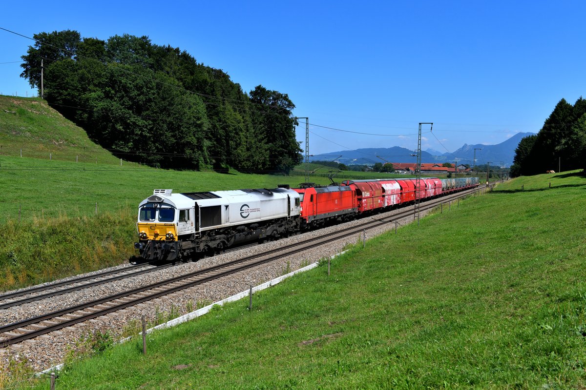 Werktags läßt sich zwischen Freilassing und Traunstein diese interessante Konstellation aus Diesel- und E-Lok planmäßig beobachten: Am 23. Juli beförderten 077 018 und 185 262 den Müllzug 50866 und konnten bei Straß mit den Salzburger Hausbergen im Hintergrund aufgenommen werden. In Traunstein geht die Diesellok wieder vom Zug und rangiert in der dortigen Müllverladungsanlage. Die E-Lok fährt mit den verbliebenen Waggons alleine weiter nach Rosenheim. 