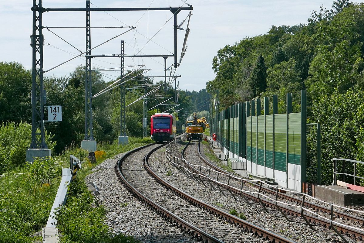 Whrend mit einem Zweiwegebagger die Schallschutzwand in Weiensberg vervollstndigt wird, befindet sich auf dem zweiten Gleis 650 315 als RB 22870 auf der Fahrt von Kissleg nach Lindau (08.07.2020).