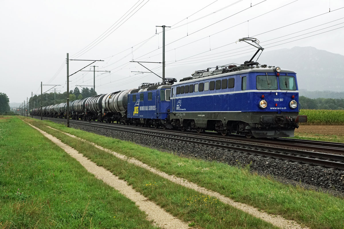 Widmer Rail Services AG/WRS.
Auch beim stärksten Regen und bei sehr schlechten Lichtverhältnissen mach die schönen blauen WRS-Lokomotiven eine gute Figur.
Sehr langer Kesselwagen mit Ae 1042 007-1, ehemals ÖBB und Re 430 111, ehemals EBT, SMB, RM, CROSSRAIL, bei Deitingen ab Cornaux unterwegs am 28. August 2020.
Foto Walter Ruetsch
