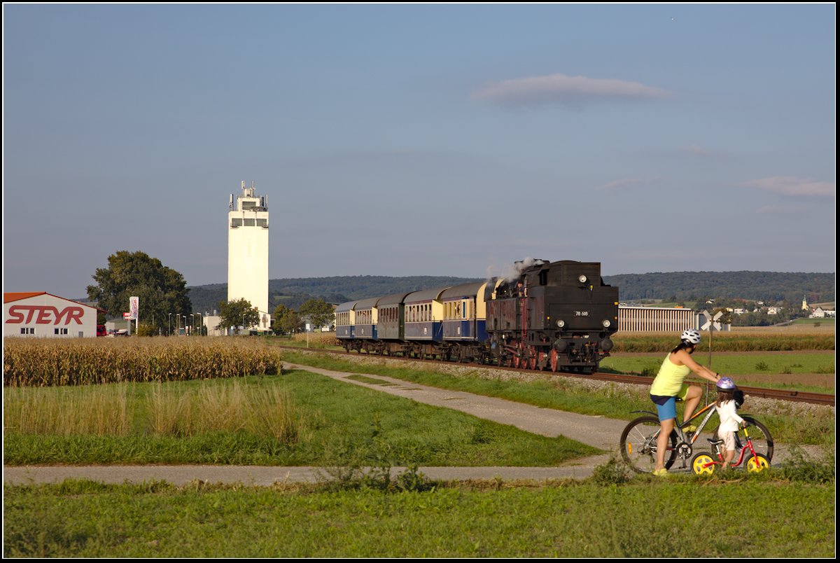 Wie es sich gehört, haben eine große und eine kleine Dame mit ihren Fahrzeugen beim Bahnübergang in Harmannsdorf-Rückersdorf gehalten, und warten die Vorbeifahrt des Sonderzugs, der mit der Dampflok 78 618 der ÖGEG bespannt ist, ab. (16.09.2018)