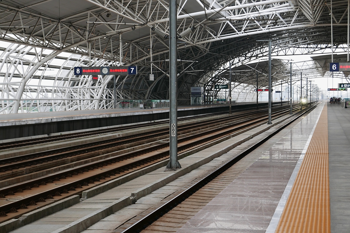 Wie leer gefegt sieht der Bahnsteig in Kunshan aus, nur wenige Minuten nachdem der Zug nach Shanghai abgefahren ist, und schon rast der nächste Zug - auf einem separaten Gleis - durch den Bahnhof Kunshan-Nan, 17.8.15 