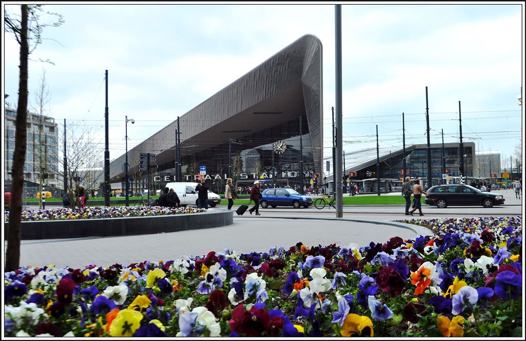 Wie so manches architektonische Highlight besticht auch der Hauptbahnhof von Rotterdam durch seine eigenwillige Form. Aber auch die Natur kommt nicht zu kurz, es sind zwar keine Tulpen, aber das Stiefmütterchenfeld vor dem Hotel Manhatten bringt auch Farbe ins Bild. (06.04.2014)