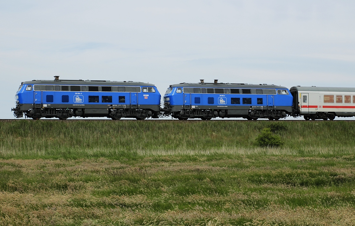 Wieder einmal mit dem IC 2310 sind die beiden Press-218 054-3 und 055-2 am 18.06.2020 unterwegs, diesmal bei Keitum. Die 218 054-2 hat inzwischen am Führerstand 2 einen Aufkleber  Vermietet an DB  erhalten.