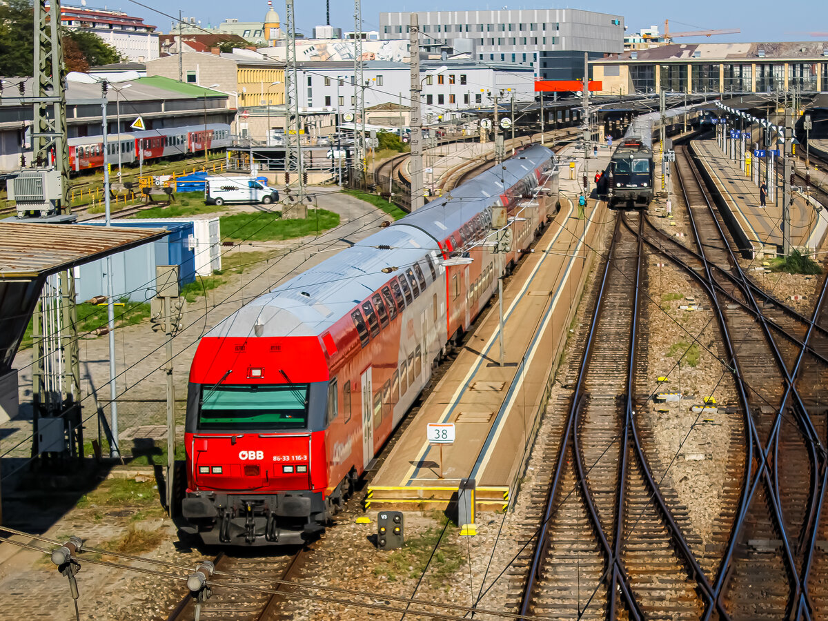 Wien. Der Wiesel SoDto-Steuerwagen 8633 116 verlässt hier am 29.09.2023 den Bahnhof Wien-West mit einem Regionalexpress nac hPayerbach-Reichenau.