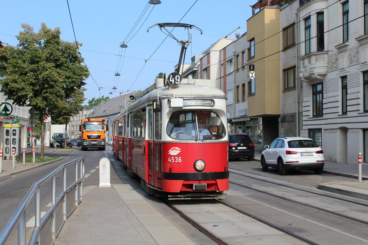 Wien Wiener Linien SL 49: Der E1 4536 erreicht am Morgen des 2. August 2018 die Haltestelle Rettichgasse in der Linzer Straße (in Hütteldorf im 14. Bezirk Penzing). - Den E1 4536 baute Bombardier-Rotax (vormals Lohnerwerke) im Jahre 1974.
