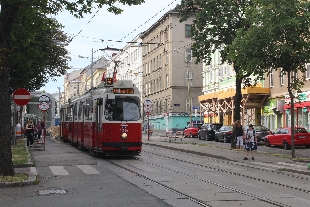 Wien Wiener Linien SL 67: E1 4314 + c5 1514 erreichen am Morgen des 27. Juni 2017 die Hst. Troststraße in der Favoritenstraße (X, Favoriten). - Links hinter der Haltestellentafel sieht man das klotzige  Stiegen- / Treppenhaus  der U-Bahnstation Troststraße (U1), die am 2. September 2017 eröffnet wird. An diesem Datum wird die U1 vom Reumannplatz nach Oberlaa verlängert und die SL 67 wird am selben Datum um etwa 11 Uhr zwischen dem Reumannplatz und Per-Albin-Hansson-Siedlung eingestellt werden.