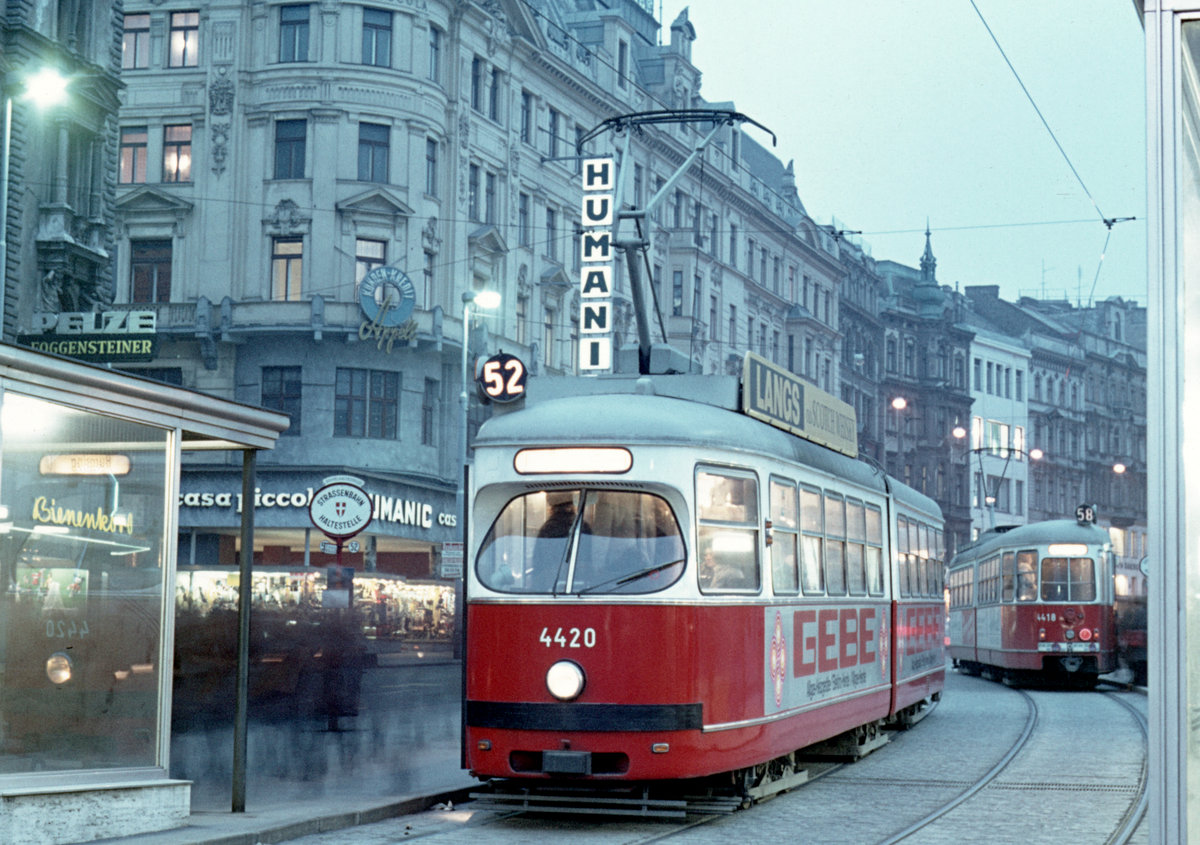 Wien Wiener Stadtwerke-Verkehrsbetriebe (WVB) SL 52 (E 4420 (Lohnerwerke 1962)) VI, Mariahilf / VII, Neubau, Mariahilfer Straße / Getreidemarkt / Messeplatz. Der 52er fährt in Richtung Opernring / Burgring. - Im Hintergrund (rechts) hält der E 4418 (Lohnerwerke 1962) auf der Linie 58. - Aufnahmedatum: 29. Jänner 1974. - Scan eines Diapositivs. Film: Kodak Ektachrome. Kamera: Minolta SRT-101.