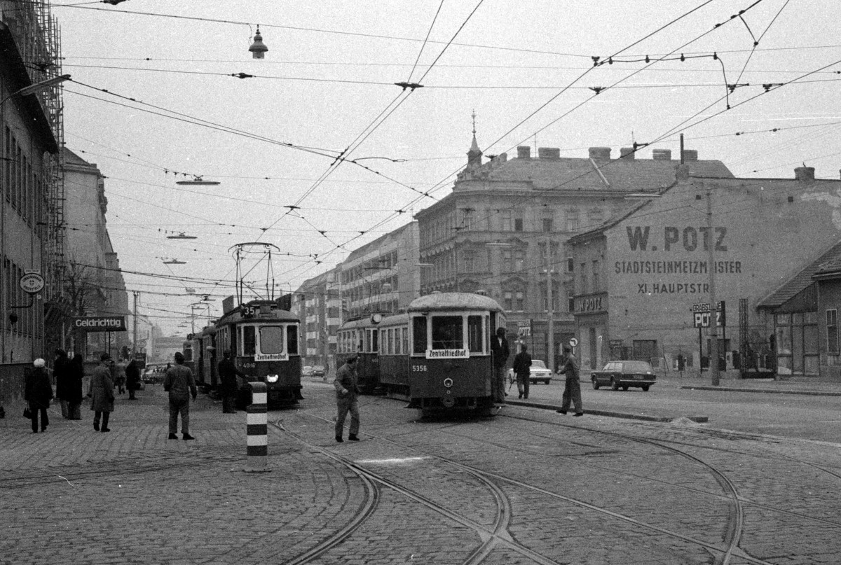 Wien Wiener Verkehrsbetriebe Allerheiligenverkehr 1975: Hochbetrieb am Vormittag des 1. November 1975 vor dem Betriebsbahnhof Simmering. Ein Dreiwagenzug der SL 35 (M 4086 + m + m) und ein Zug der SL 29 werden von einem Zugabfertiger zurückgehalten, während ein anderer Dreiwagenzug (m3 5356 + m + M 40xx) ins Bahnhofsgebiet rangiert. - Scan von einem S/W-Negativ. Film: Kodak Tri X Pan. Kamera: Kodak Retina Automatic II. 