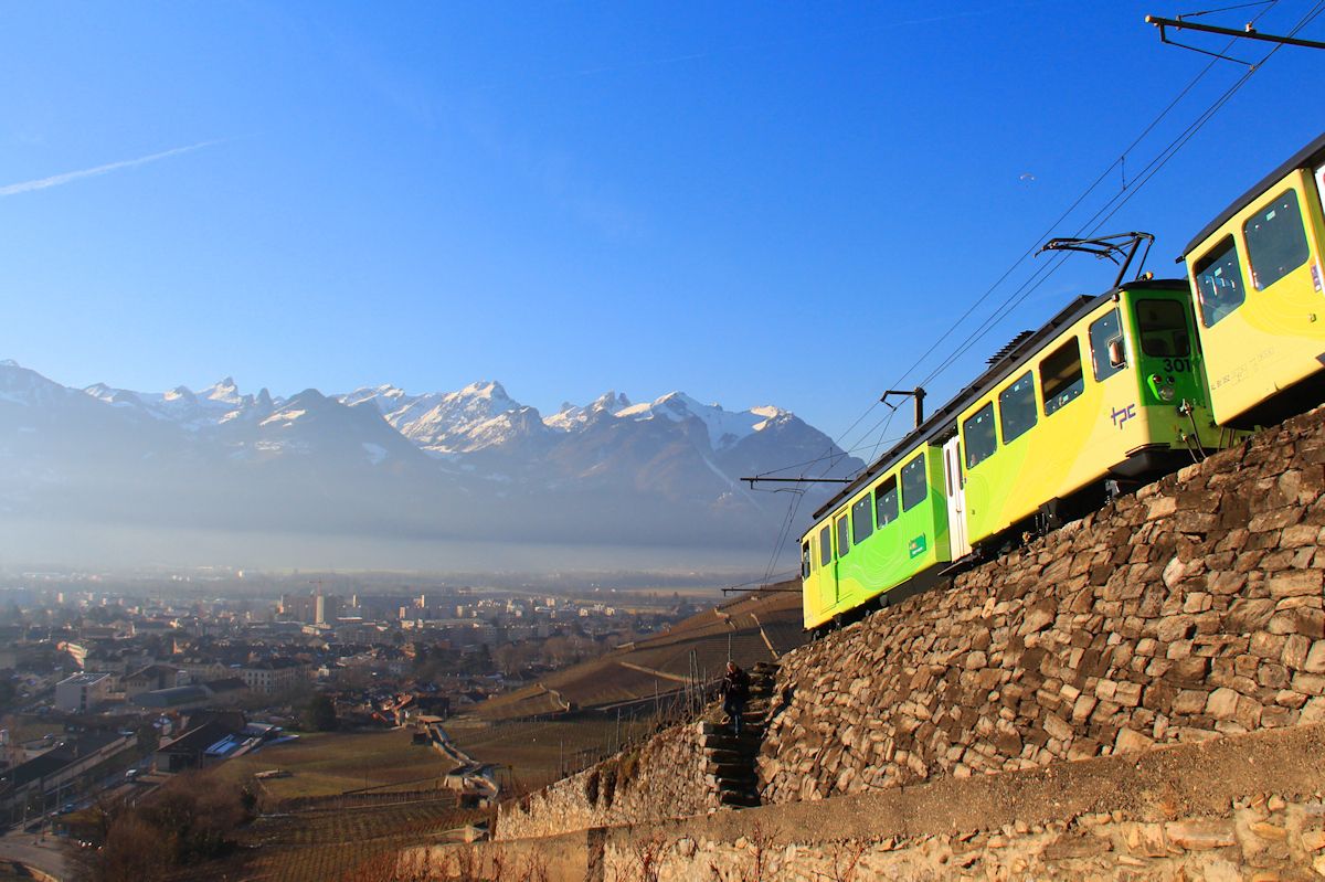 Winter in den Rebbergen von Aigle - der grüne Zug der Aigle-Leysin-Bahn Motorwagen 301 + Steuerwagen 352, 25.Januar 2016. Mit einem winzigen Gleitschirmflieger am Himmel. 