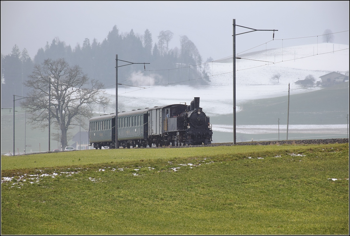 Winterdampf des Vereins Historische Emmentalbahn. Dampflok Ed 3/4 Nr. 2 der Solothurn-Münster-Bahn auf dem Bahnübergang bei Dürrenroth. Februar 2018.