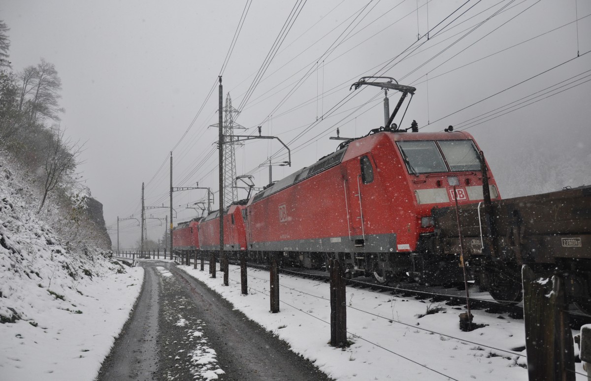 Wintereinbruch am Gotthard: Drei BR 185 verlassen am 22.10.2014 mit ihrem Güterzug langsam den Bahnhof Göschenen in Richtung Norden, nachdem sie dem schnelleren ICN den Vortritt gelassen haben. 