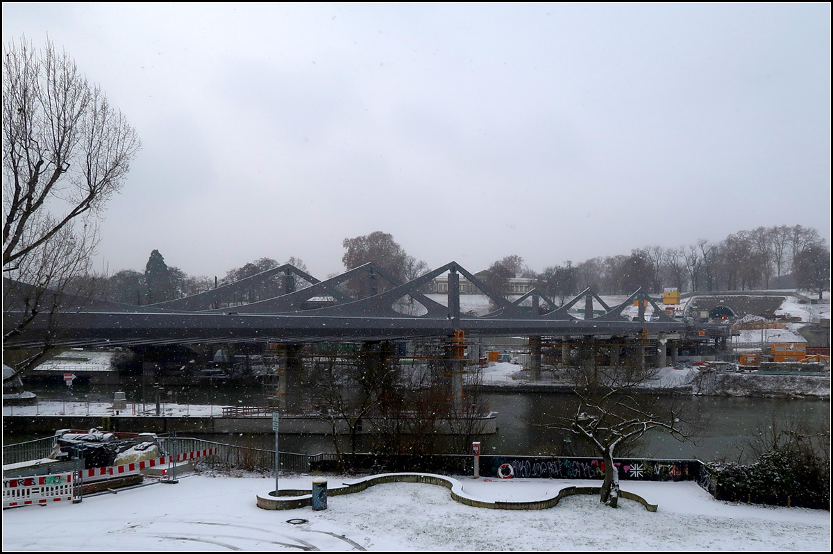 Winterliche Brückenbaustelle -

Die neue Bahnbrücke über den Neckar in Stuttgart-Bad Cannstatt im Winter. In Bildmitte hinter der Brücke das Schloss Rosenstein. Der erste Bahntunnel führte direkt unter dem Schloss hindurch. Der zweite, in Betrieb befindliche viergleisige Tunnel befindet sich von hier aus gesehen links neben dem Schloss. Die neue Tunnels unter dem Rosensteinpark zukünftig auf der anderen Seite. Das Portal für den zweigleisigen Fern- und Regionalbahntunnel ist rechts erkennbar. Direkt rechts daneben wird dann auch das Portal des S-Bahntunnels entstehen. Die S-Bahn wird dann im Tunnel die neue nach oben offene Station Mittnachtstraße erreichen. Dort vereinigen sich die Gleise mit denen aus Richtung Feuerbach. Weiter geht es dann im Tunnel zum Hauptbahnhof.

24.01.2019 (M)