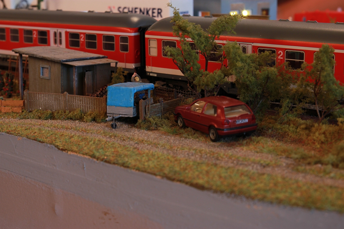 Wir haben ein ganzes Stück weiter gestaltet...
RE auf der Durchfahrt, im Vordergrund wird im Schrebergarten das Holz für den Winter gehackt.
Modellbahntage Markdorf, Oktober 2014