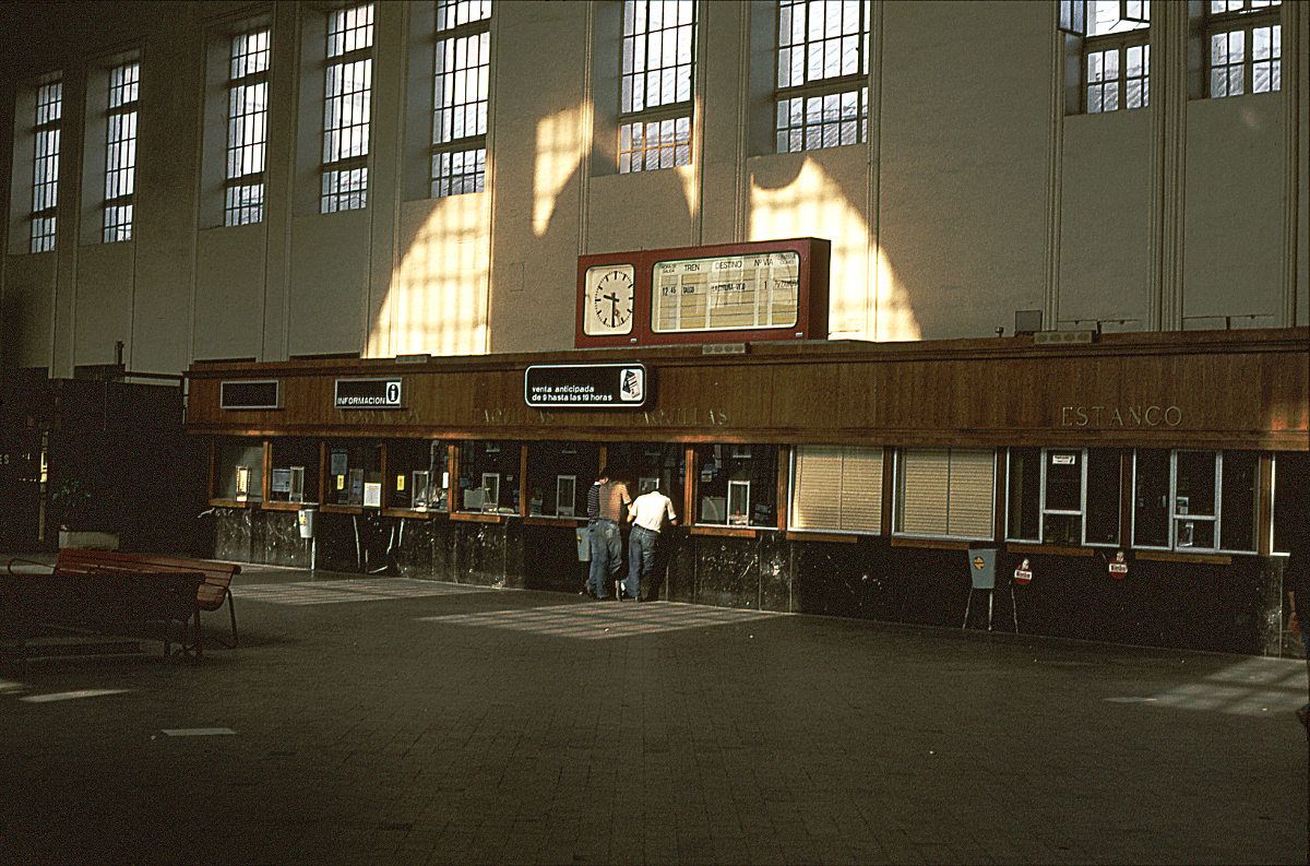 Wir sehen die Eingangshalle des Bahnhofs Madrid Principe Pio oder Estacion del Norte. Sie ist sehr gepflegt und strahlt Gediegenheit aus. Viel ist aber nicht los: Die Uhr zeigt 9.30 Uhr, der nächste Zug des Fernverkehrs ist der Talgo nach La Coruna und Vigo um 12.45....... Oktober 1983.
Canon AE1, Canoscan, GIMP