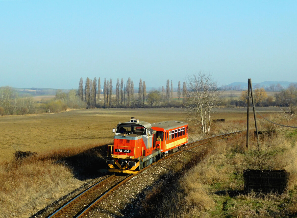 Wirtschaftlicher Werktagszug: eine Verschublok + 1 Bz Beiwagen. Wenn es kein 117er Triebwagen in Győr gibt, in diesem Fall ist der Zug somit sichtbar.
478 204 (M47 1204) mit dem Zug 39552 kurz nach Veszprémvarsány. Das Ziel ist Bakonyszentlászló. Das Bild ist von meines Sohn: Márk Németh
Veszprémvarsány, 26.03.2022.