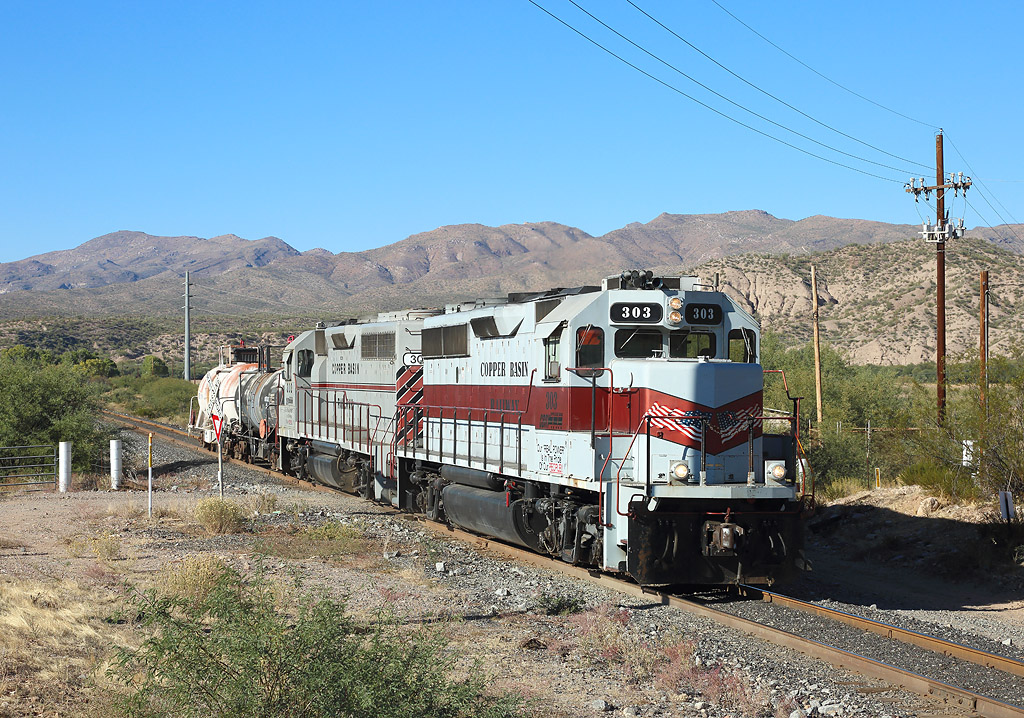 With the miners on strike and no ore trains running, the Copper Basin Railroad ran security trains to protect its infrastructure from vandalism/sabotage.

303 & 302 pass East Tristan Rd whilst hauling a security train from Ray Jct to Hayden, 1 Nov 2019