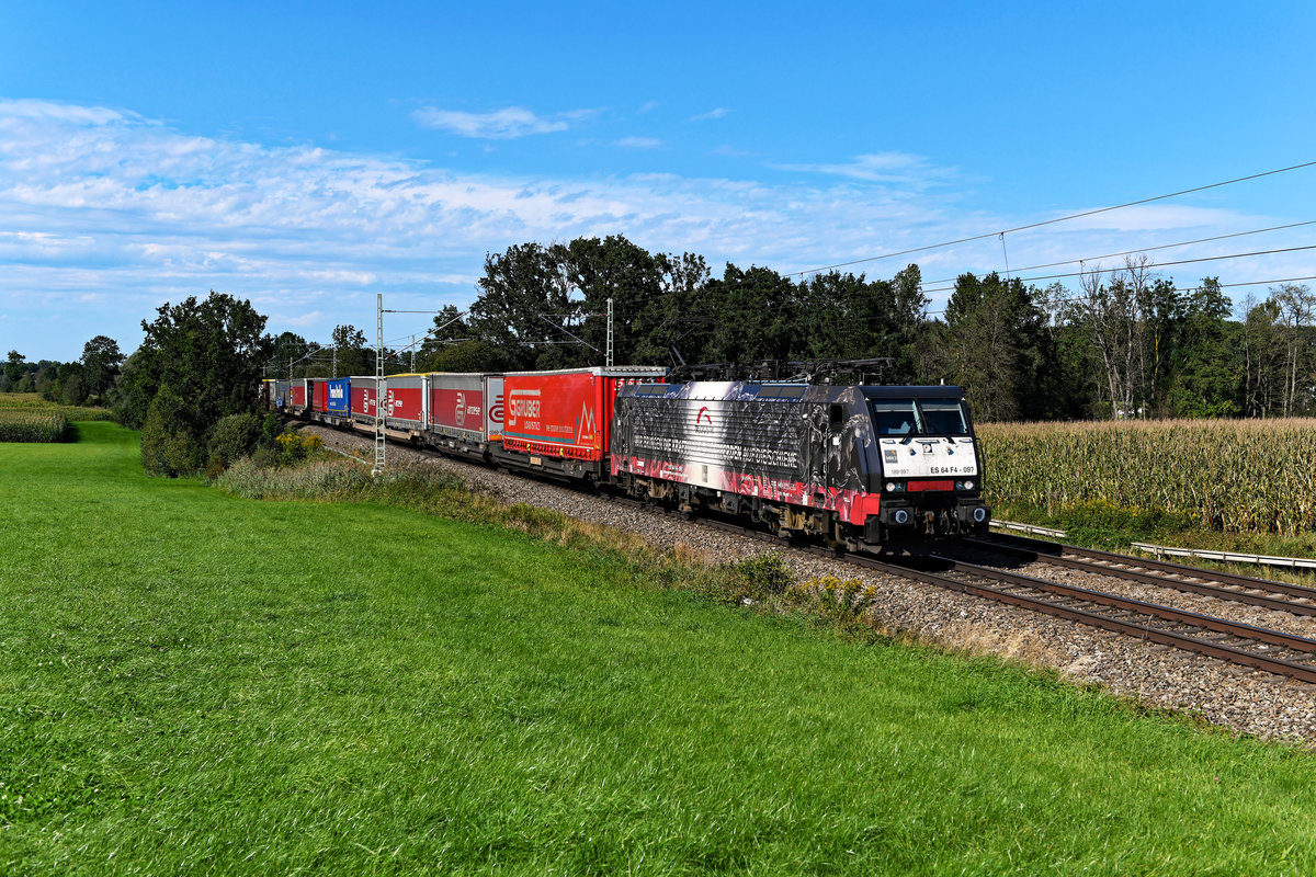 Wohl bald Geschichte ist der Einsatz von Loks der Baureihen 182 und 189 bei TXLogistik. Die letzten beiden Exemplare sollen zeitnah an den Vermieter MRCE zurück gegeben werden. Es ist davon auszugehen, dass sie dann auch ihre attrakiven Folierungen mit den Flammen- und Pferde-Motiven verlieren werden. Am 05. September 2020 konnte ich die 189 997 vor dem DGS 43155 von Köln Eifeltor nach Verona Q.E. am ehemaligen Block Hilperting im bayerischen Voralpenland fotografieren. Auch auf diesem Bild wird die an diesem Tage bestehende merkwürdige Wetterlage mit dem feststehenden Wolkenband ersichtlich (Hinweis: ein Signal hinter der Lok wurde digital entfernt).