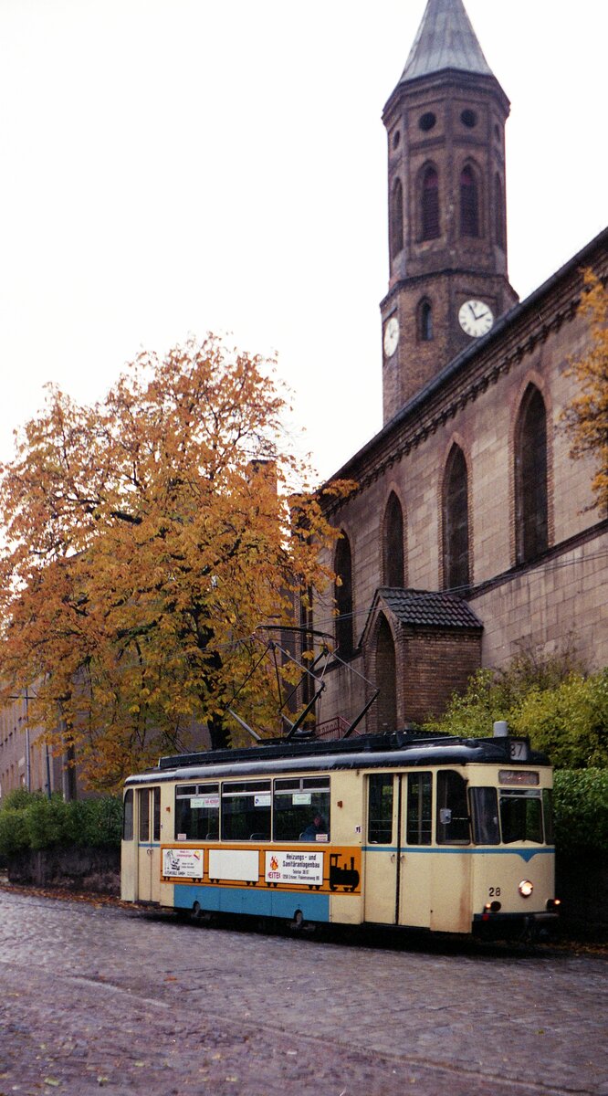 Woltersdorfer Straßenbahn__Tw 28 [T59M; VEB Gotha 1959; 1987 ex Dessau] auf Talfahrt an der Kirche in Woltersdorf.__29-10-1992