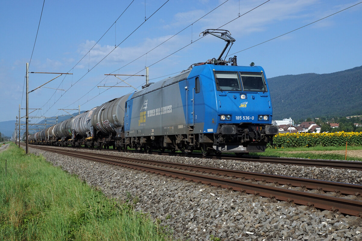 WRS Widmer Rail Services AG.
185 536-0 mit einem Kesselwagenzug zwischen Bettlach und Selzach auf der Fahrt in Richtung Solothurn am 11. August 2021.
Foto: Walter Ruetsch