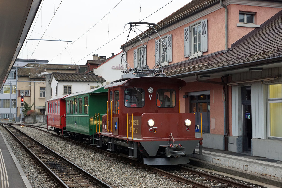 WSB(AAR): In Zukunft wird das  FARBIGE BÄHNLI  nicht mehr durch das Wynental- und Suhrental fahren. Am 9. November 2017 fand die letzte nicht öffentliche Fahrt in Form einer Überführung von Aarau nach Menziken statt.
Der Nostalgiezug mit dem Te 2/2 49 wurde kurz vor seiner letzten Abfahrt in Aarau bei sehr schlechtem Wetter abgelichtet. Vom Salonwagen BSE 4/4 hat sich die WSB (AAR) bereits im Jahre 2012 verabschiedet. Dank der Firma Bärtschi von Reinach hat er als Sitzungszimmer überlebt. Die beiden ehemaligen ESZ B2 29 und B2 30 wären beim Orion-Club in Zug besser aufgehoben, als auf dem Schrottplatz. In der Obhut dieses Vereins befindet sich bereits der bei der OJB zurückgeholte und mustergültig aufgearbeitete CFe 4/4 3, der bei der Elektrischen Strassenbahn Zug von 1913 bis 1955 im Einsatz stand.
Foto: Walter Ruetsch 

 








