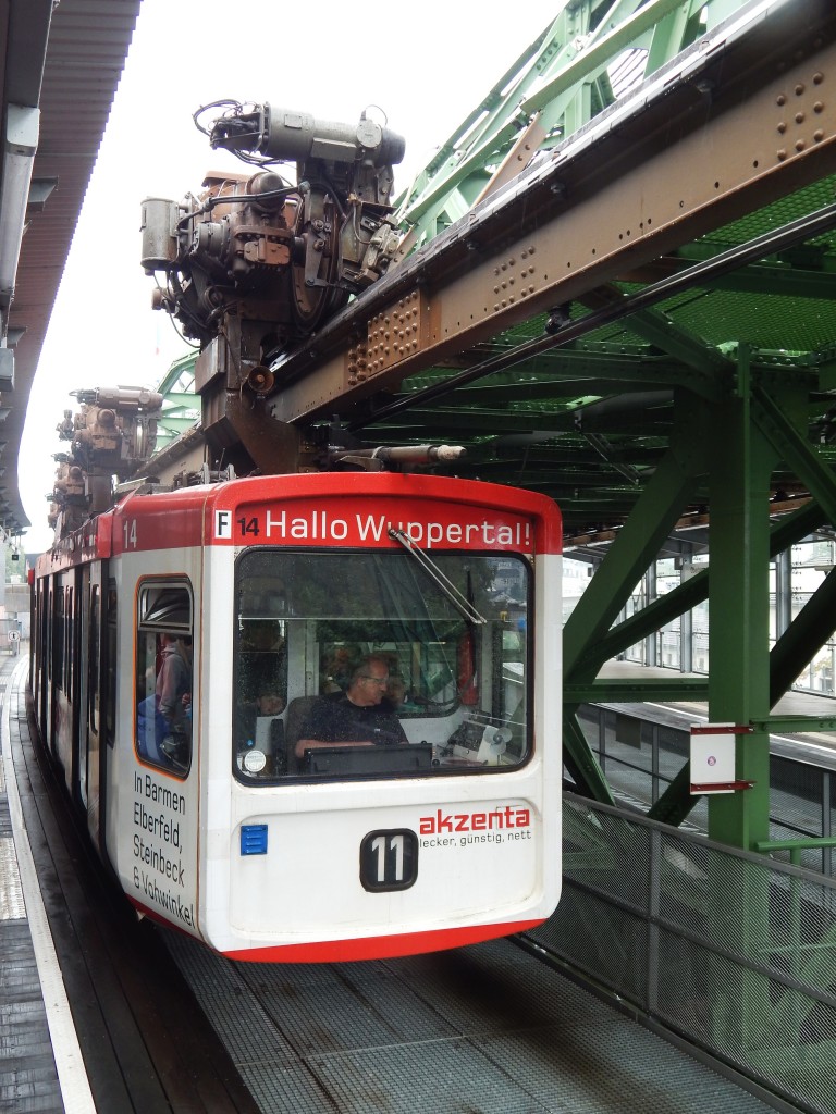 WUPPERTALER SCHWEBEBAHN- die 2.:Auf diesem Bild vom 29.6.2014 kann man sehr gut die Aufhängung des Waggons an der Führungs-/Gleitschiene erkennen.
Ich muss es gestehen: Die Fahrten mit diesem Bahn-Unikat haben echt ein gewisses
Sucht-Potential: das leichte Schaukeln des Waggons in ca. 10-12m Höhe über Wupper und

Straßenverkehr haben mich veranlasst,mehrfach die gesamte Strecke hin und zurück abzufahren.Ich beneide die Wuppertaler für dieses geniale Nahverkehrsmittel....