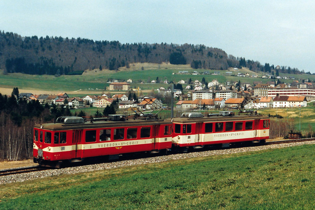 YSC: Sehr seltene Doppeltraktion bestehend aus den Triebwagen ABe 2/4 11 und 12 mit Baujahr 1946 bzw. 1947 als Regionalzug Sainte-Croix - Yverdon-les-Bains unterhalb Sainte-Croix unterwegs im Mai 1987. Der unterschiedliche Anstrich diente einem Farbversuch. Während der Triebwagen 11 im Jahre 1991 an eine Privatperson verkauft, wurde der Triebwagen 12 im selben Jahr abgebrochen.
Foto: Walter Ruetsch  