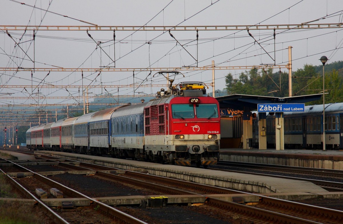 ZSK 350018 braust am 23.8.2013 früh morgens mit einem bunt gemischten Schnellzug aus Prag kommend durch den Bahnhof Zabori nad Labem.