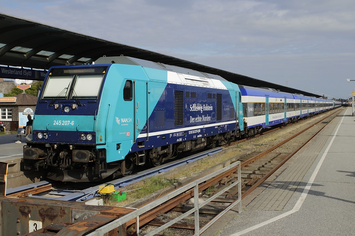 Zu den Hauptverkehrszeiten werden wegen des starken Fahrgastaufkommens zwei RE 6-Wendezüge zusammengekoppelt. Ein solcher beträchtlich langer Zug steht mit der 247 207-6 am Schluss am 11.06.2020 abfahrbereit in Westerland.