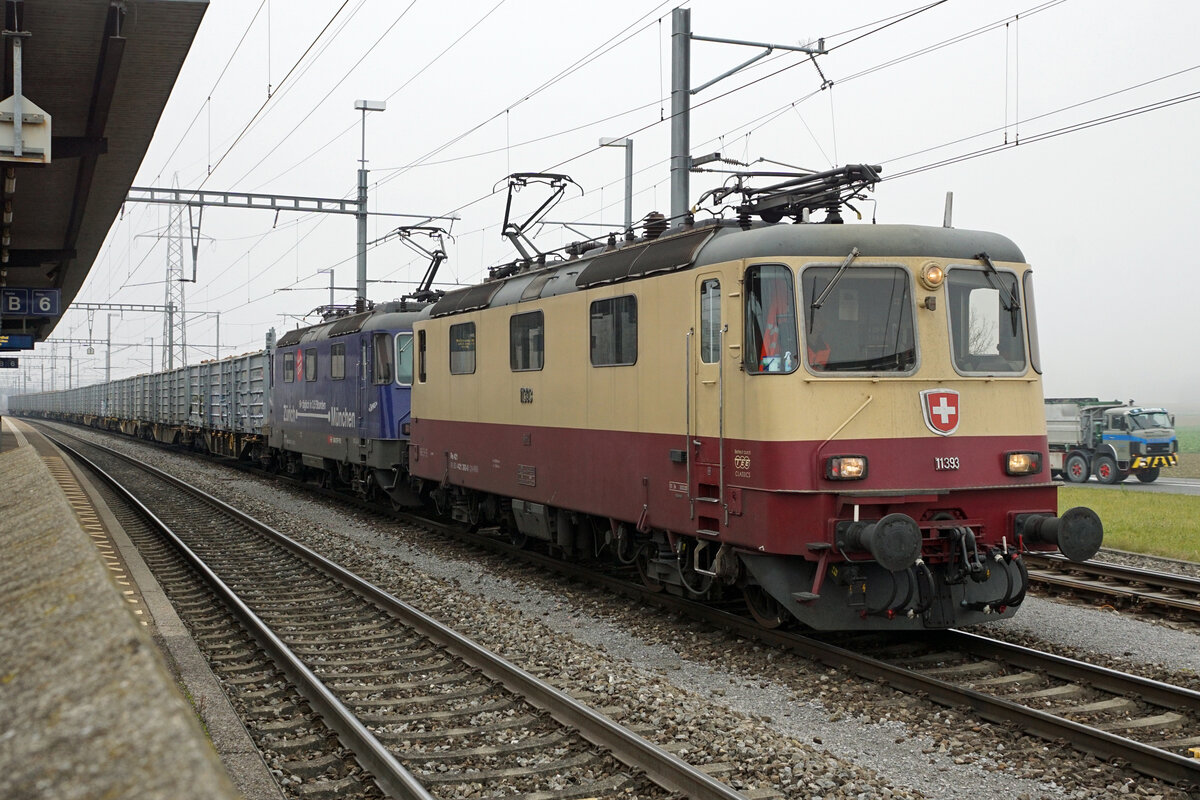 ZUCKERRÜBENKAMPAGNE SCHWEIZ 2021
Zuckerfabrik Frauenfeld
Am 12. November 2021 stand das Duo TEE TR Re 421-393 von International Rolling Stock Investment (IRSI) und die Re 421 371-6 von SBB Cargo im Rübendienst zwischen Islikon und Turgi.
Zur Abfahrt bereit im Bahnhof Turgi.
Epochengerecht zu den beiden SLM/BBC Lokomotiven mit Baujahr 1984-1985 ist der SAURER Lastwagen im Hintergrund, der auch im Jahre 2021 noch im Einsatz steht.  Im Jahre 1983 hat SAURER den letzten zivilen Lastwagen ausgeliefert.
Bei diesen drei starken und robusten Fahrzeugen handelt es sich um echte SCHWEIZER QUALITÄT.
Fotostandort hinter einer Mauer am öffentlich zugänglichen Perronende.
Foto: Walter Ruetsch

