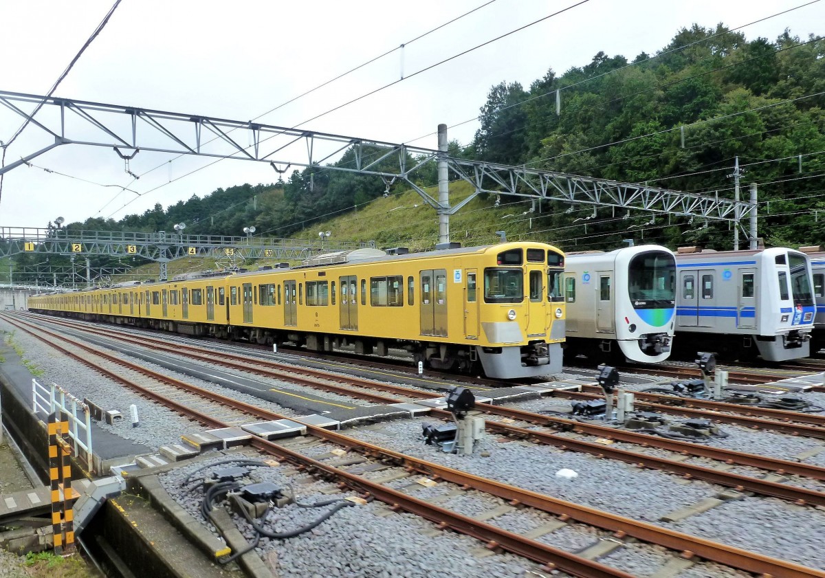 Züge des Seibu-Konzerns: Drei Züge in der Abstellanlage Musashigaoka; vorn der gelbe Zug 2073 aus der Serie 2000 (1977-1992 gebaut; heute vorhandene Serie 2000-Züge sind 26 Achtwagenzüge, 17 Sechswagenzüge, 23 Vierwagenzüge, 10 Zweiwagenzüge, die sich unterschiedlich kombinieren lassen). 23.Oktober 2011. 