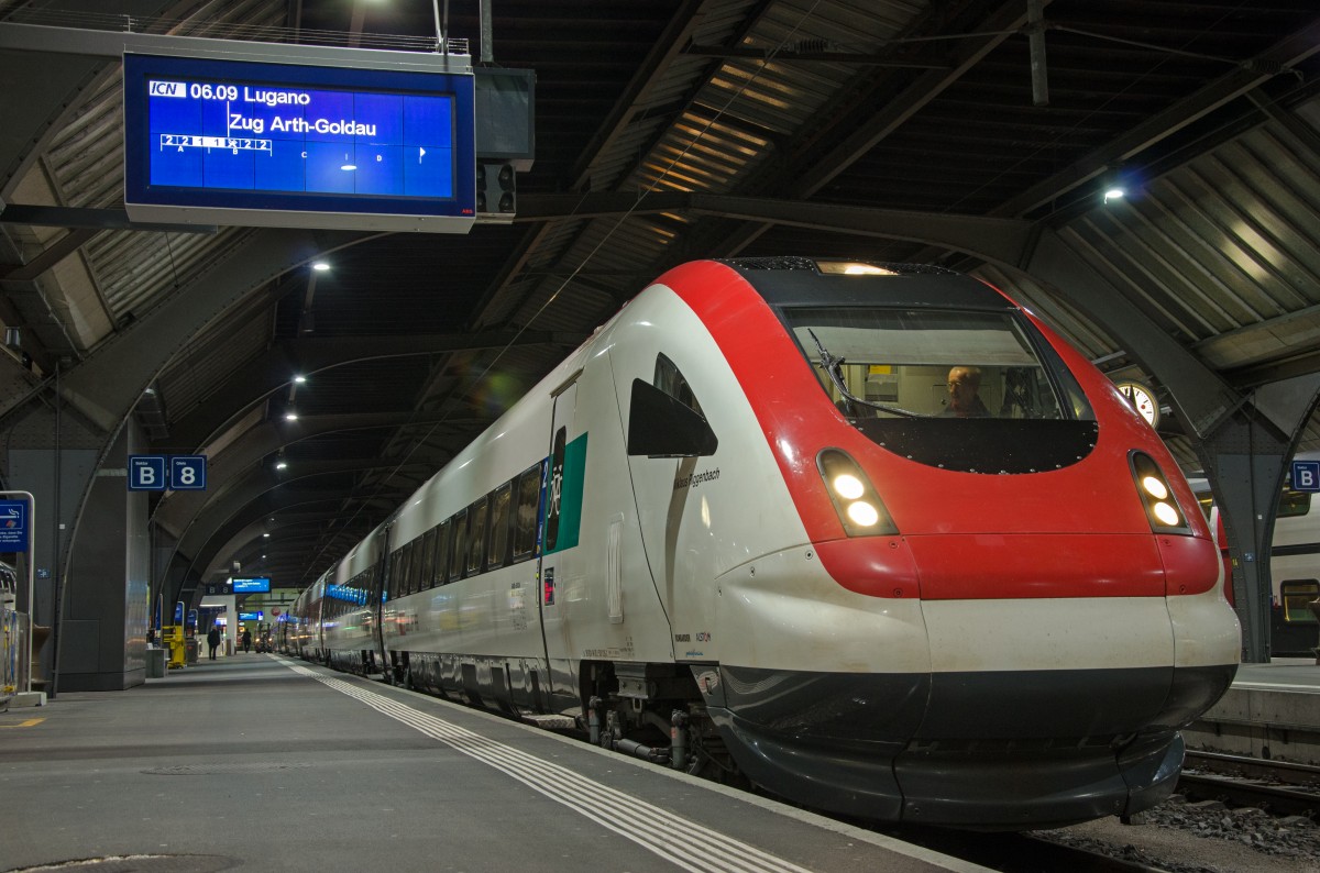 Zürich Hauptbahnhof, Gleis 8, Dienstag den 03. Februar 2015 um 06:03 Uhr in der Früh. Hier steht der Zug ICN 859 (ICN = InterCity–Neigezug) nach Lugano abfahrbereit. Der Zug fährt über Arth-Goldau an der Rigi in den Süden nach Lugano. Der ICN trägt den Namen „Niklaus Riggenbach“. Riggenbach war der Erbauer der ersten Zahnradbahn Europas welche auf die Rigi führt. Somit passt der Name bestens zur befahrenen Strecke. Es handelt sich hier um den Zug RABDe 500 ICN 94 85 0 500 035–6 CH–SBB.