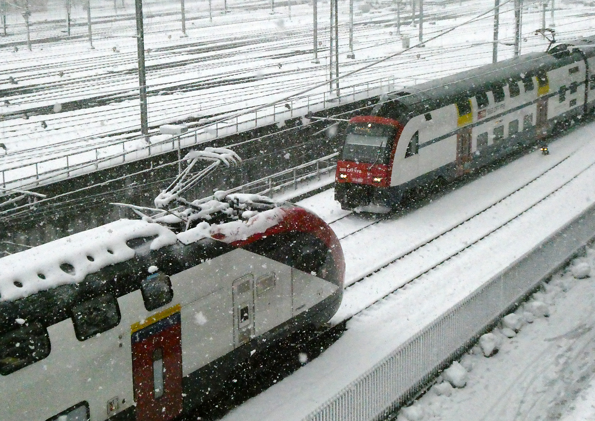 Zürich HB, Blick vom Negrellisteg auf das Gleisfeld und das Schneetreiben: Der FV-Dosto im Vordergrund scheint schon einige Zeit hier zu stehen. Rechts fährt die S24 aus dem Bahnhof aus. Zürich HB, 2.12.2023