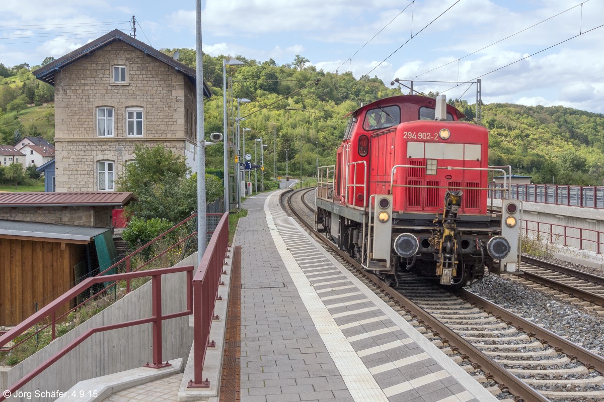 Zufallstreffer am gleichen Platz, aber 12 Jahre später als 991477: Am 4.9.15 fuhr 294 902 als Lz durch Goßmannsdorf zum Einsatz auf der Mainländebahn bei Marktbreit. Die Station wurde in der Zwischenzeit komplett umgebaut und nur das Empfangsgebäude blieb stehen. 