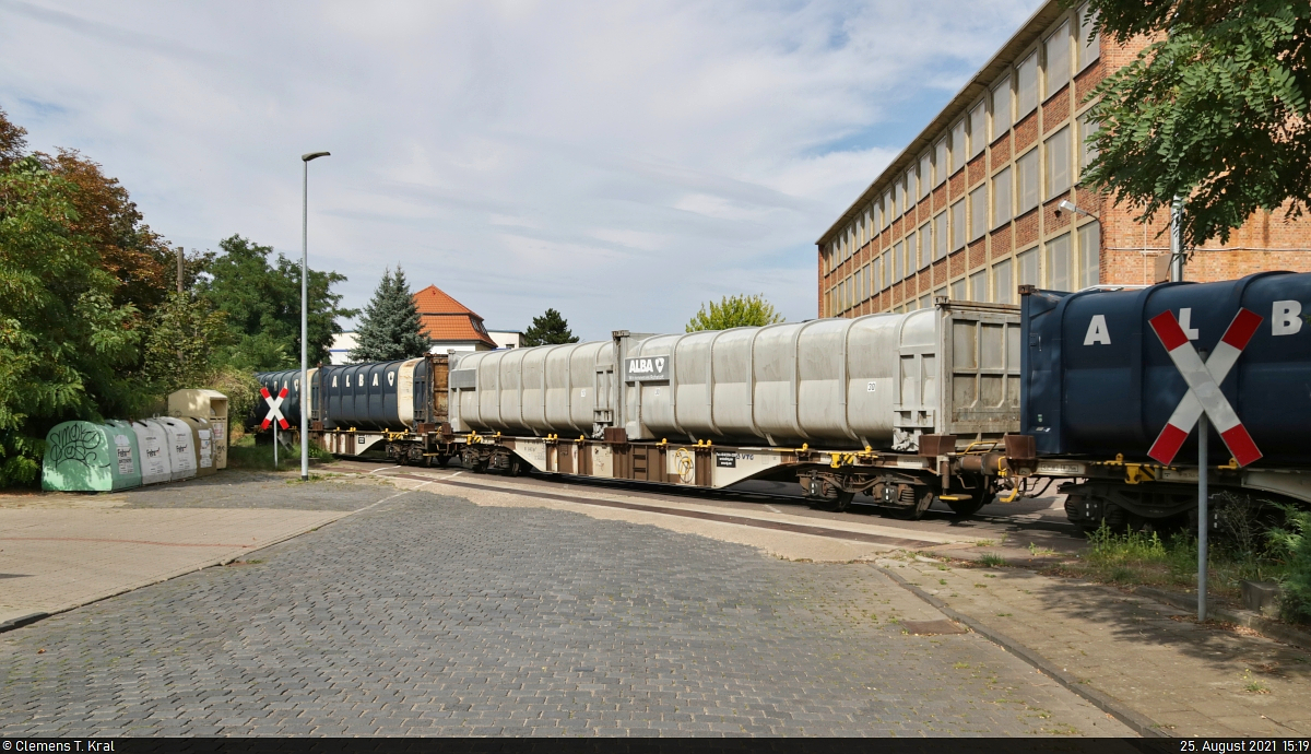 Zuführung des Müllzuges von Braunschweig zur Remondis Thermische Abfallverwertung GmbH in Staßfurt. Containertragwagen mit der Bezeichnung  Sgns <sup>113</sup>  und Müllcontainern der Alba Group werden auf dem Anschlussgleis über die Atzendorfer Straße geschoben.

🧰 VTG AG
🕓 25.8.2021 | 15:19 Uhr
