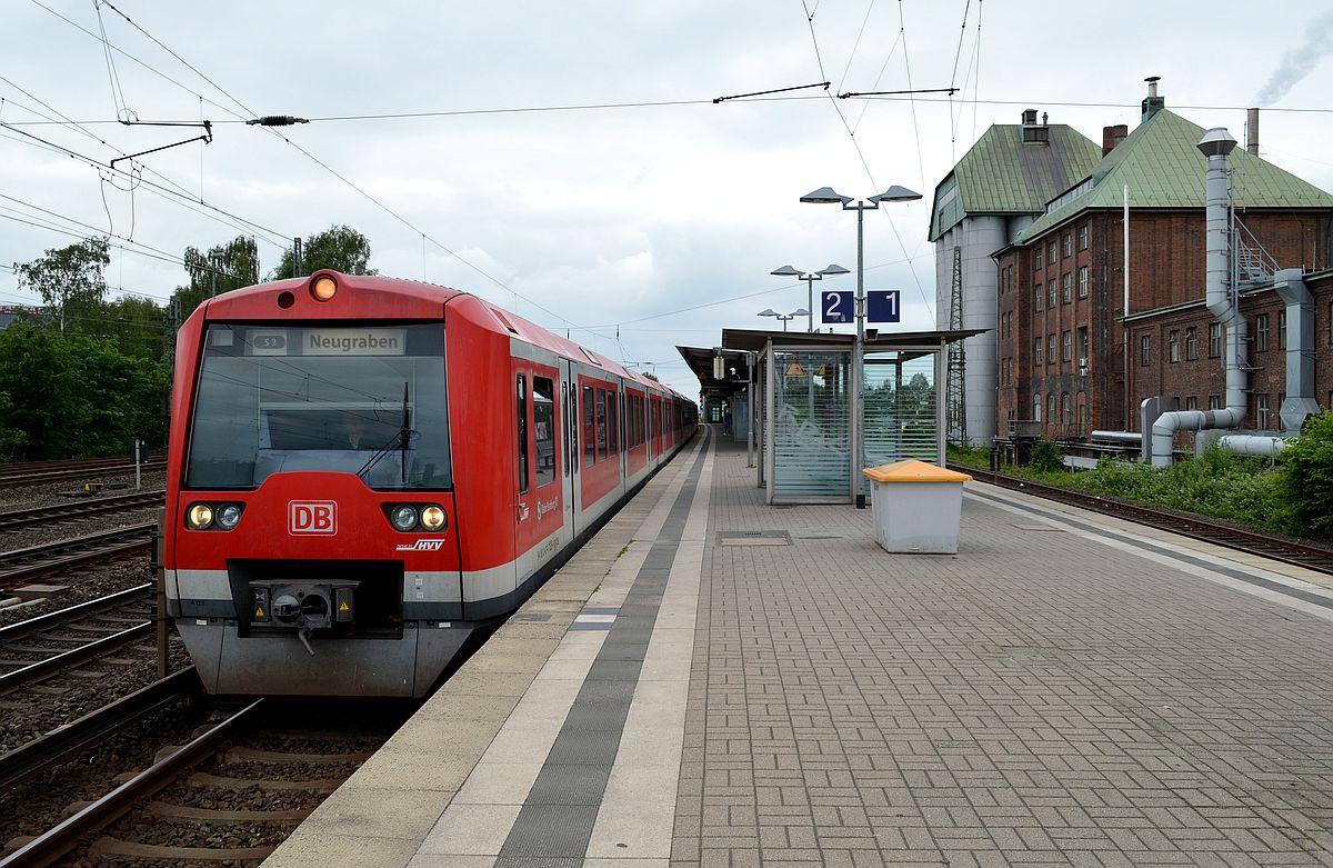 Zug der Hamburger S-Bahnlinie 3 Richtung  Neugraben  an der Station  Eidelstedt  - mit ihrem charakteristischen Fabrikgebäude. 1.6.2014