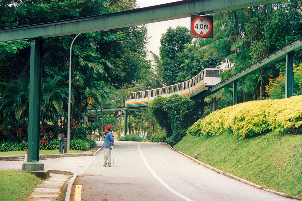 Zug J der SDC Sentosa Monorail fährt von der Fort Siloso Station 3 kommend in Richtung Cable Car Station 4. Die Schiene oben im Vordergrund ist die Trasse von der Underwater World Station 2 zur Fort Siloso Station 3. Bild vom 08.Mai 2002. (Fotoscan)